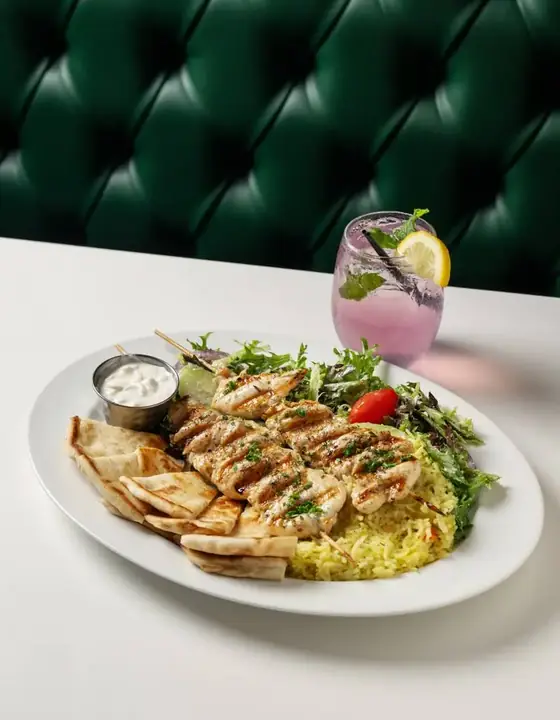 Grilled chicken souvlaki skewers with pita, rice pilaf, greek salad and tzatziki
