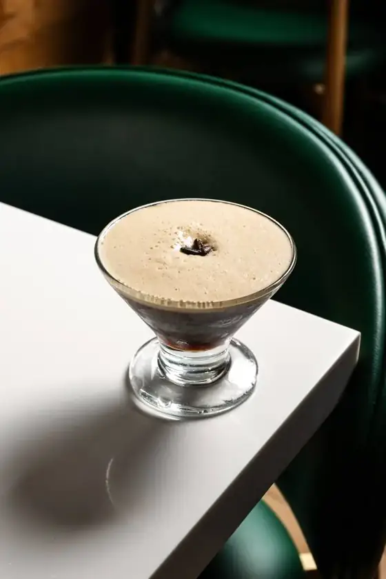 An espresso martini topped with coffee beans